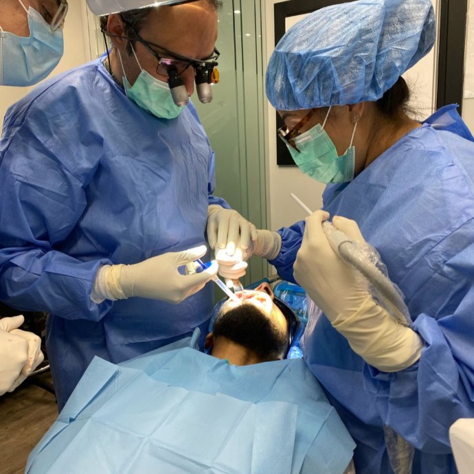 Dental Implant Expert Dr Alfonso Rao accompanied by a dental nurse on a dental surgery